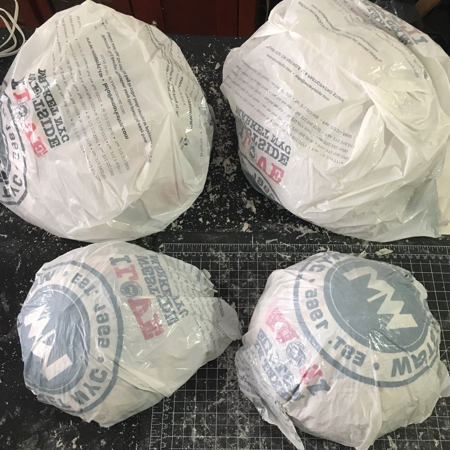 Four papier-mâché domes covered in plastic, sitting together on a table