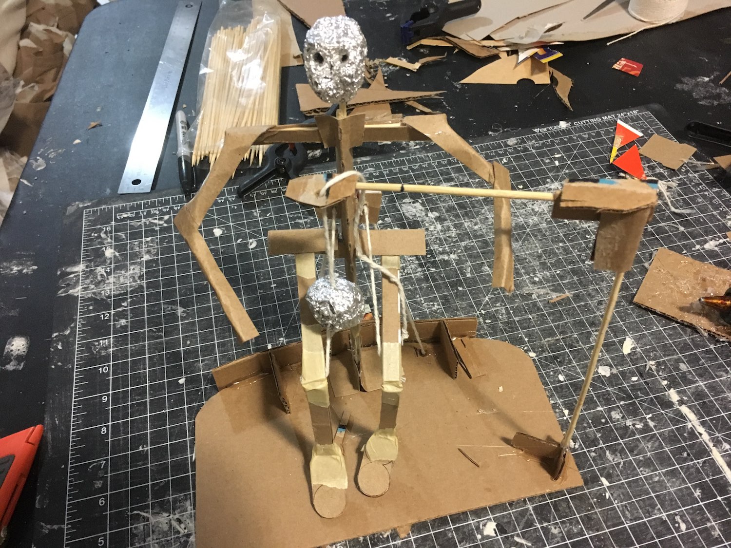 A small cardboard skeleton with a skull floating in front of it