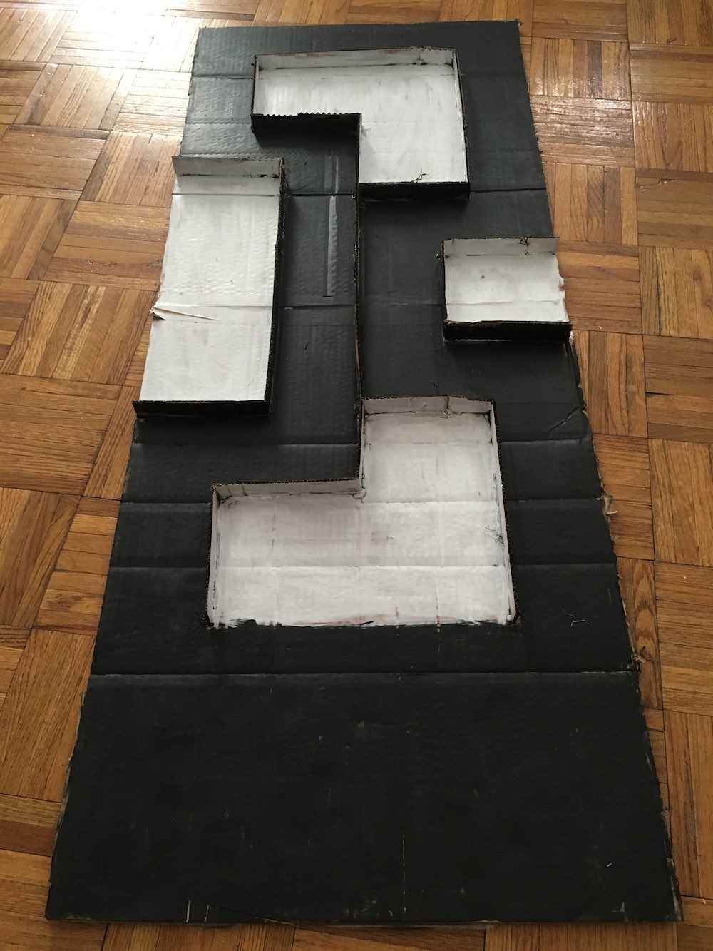 A mockup of the previously-pictured path made of short strips of cardboard glued together to form walls
