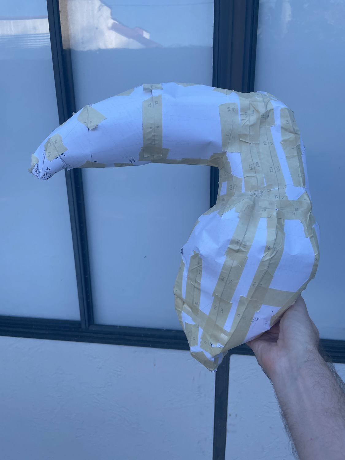 The 3D model of the bird body now rendered life-size (or larger than life-size?) in paper, being held aloft