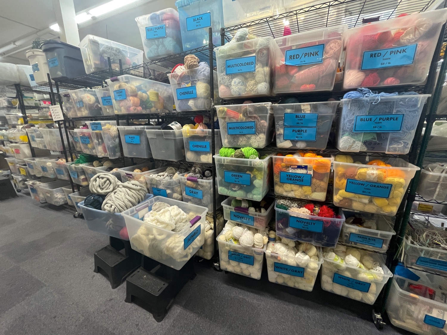 Plastic bins full of various crafting supplies stacked to the ceiling