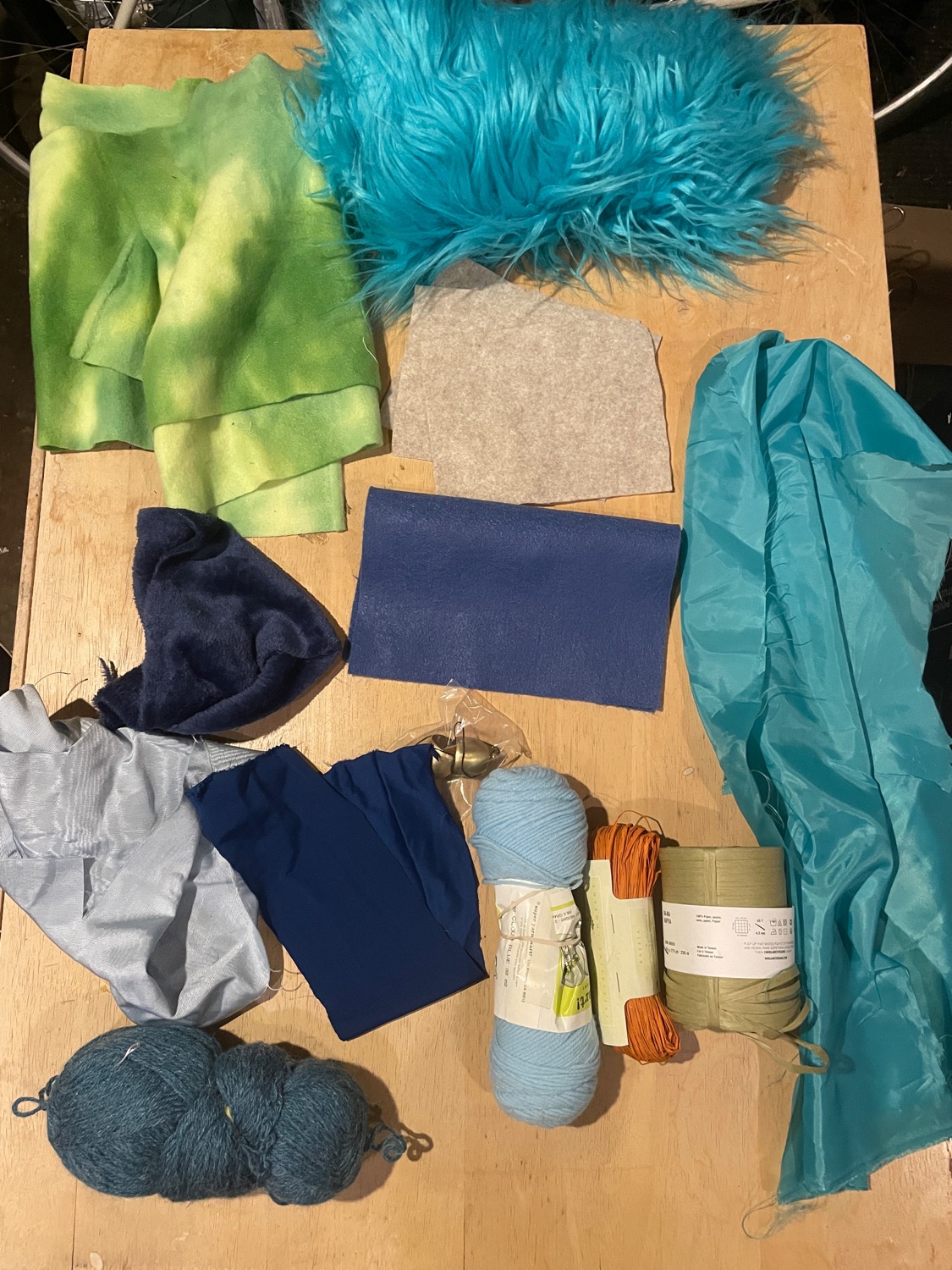 A table full of mismatched scraps of yarn and fabric
