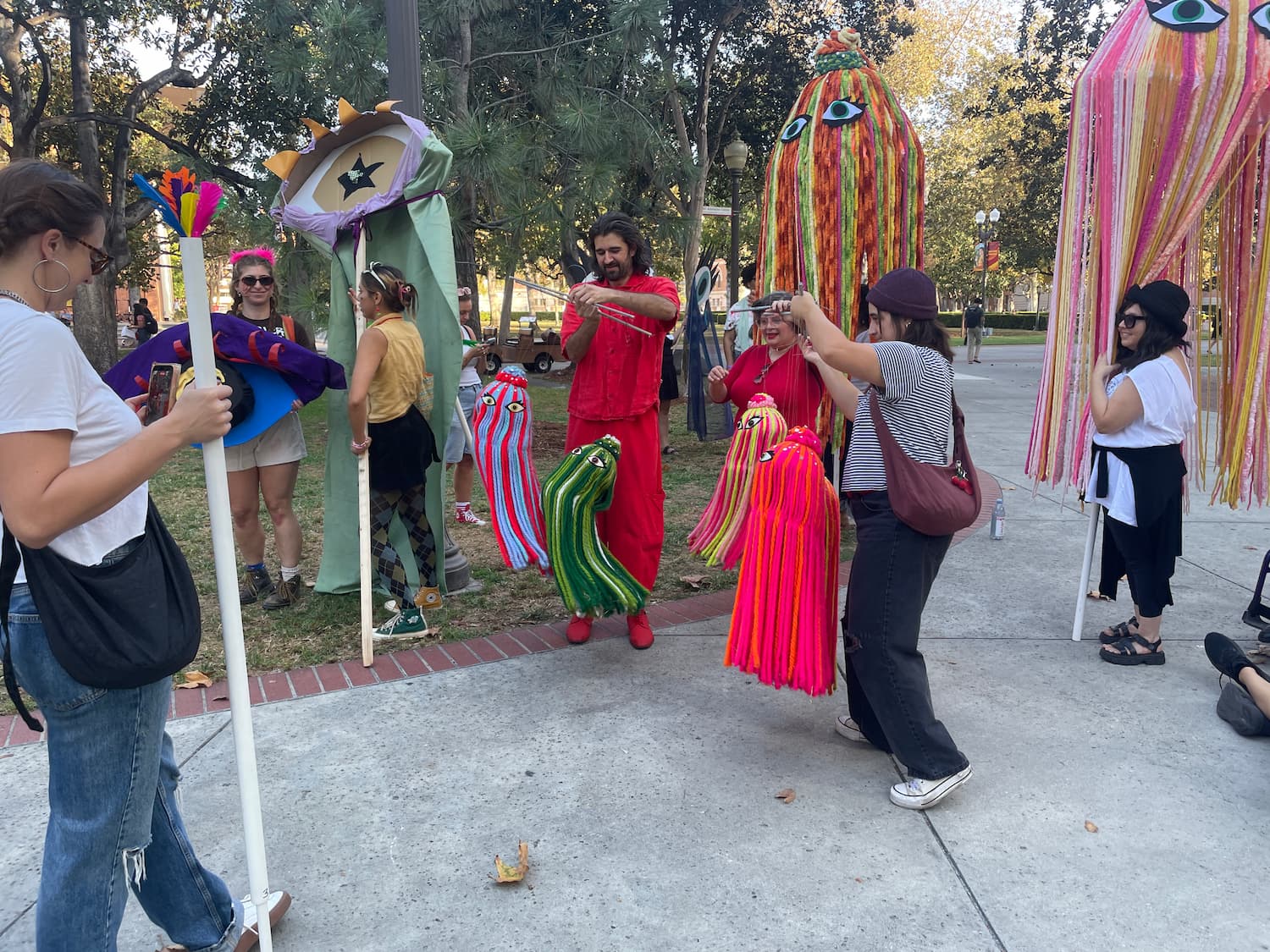 A bunch of puppets milling about on a grassy quad
