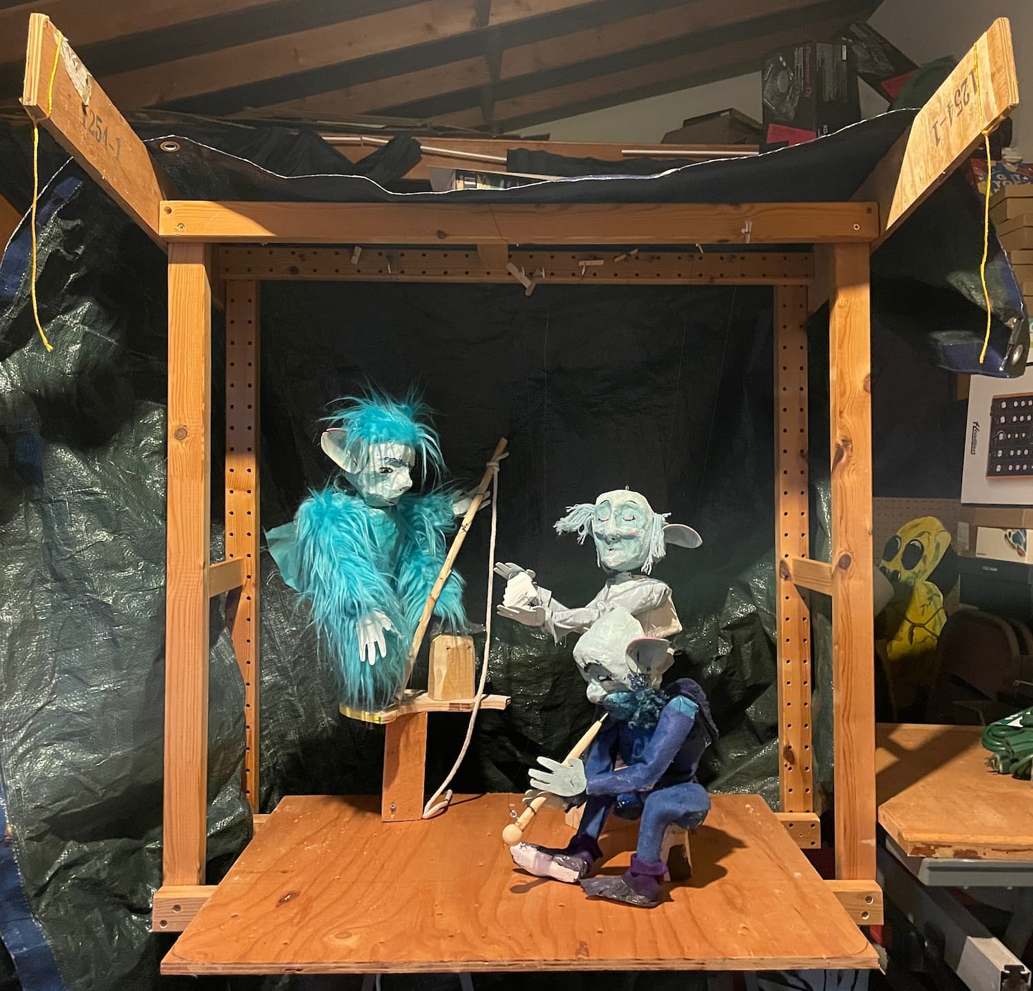 A little marionette stage in progress, the three blue characters from past weeks strung up in their performance poses