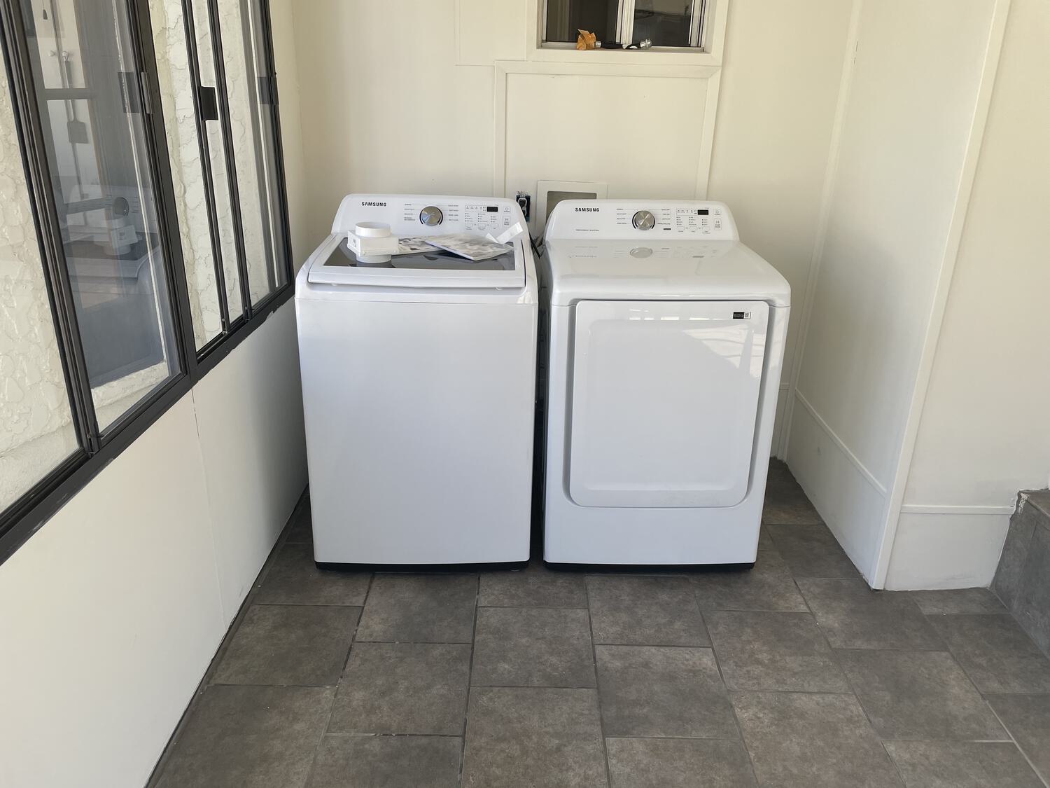 A washer and dryer, freshly installed in an empty room