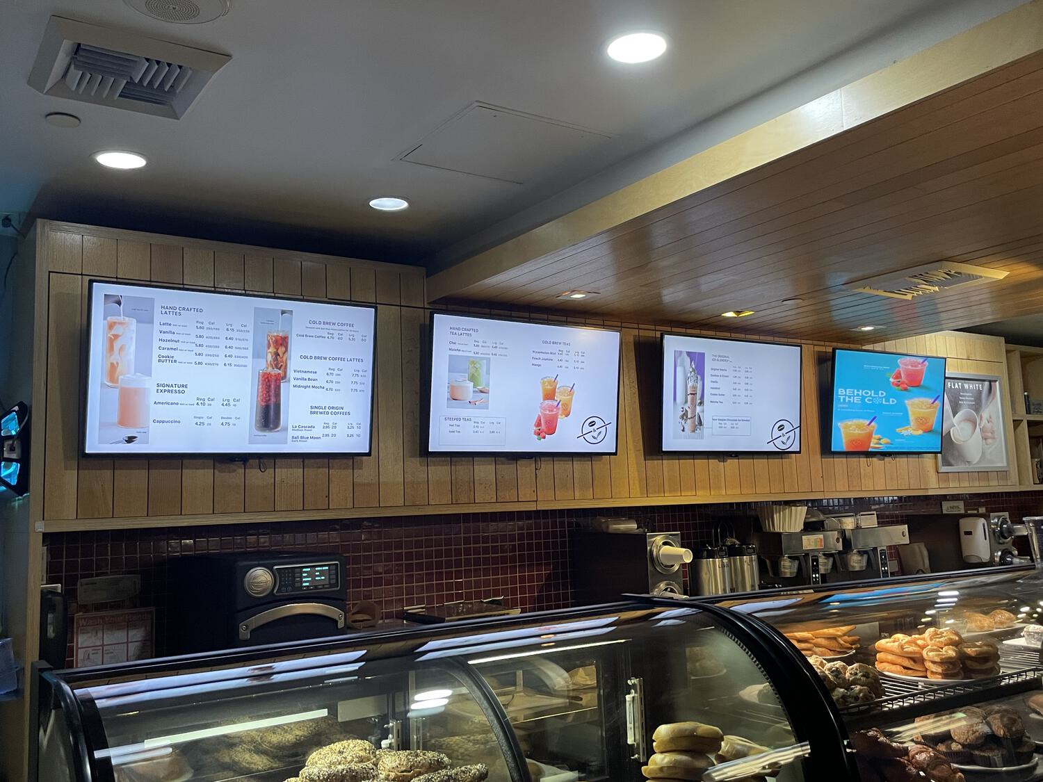 Screens displaying the menu behind the counter at a Coffee Bean & Tea Leaf, littered with ruthlessly resized stock photos of the offerings