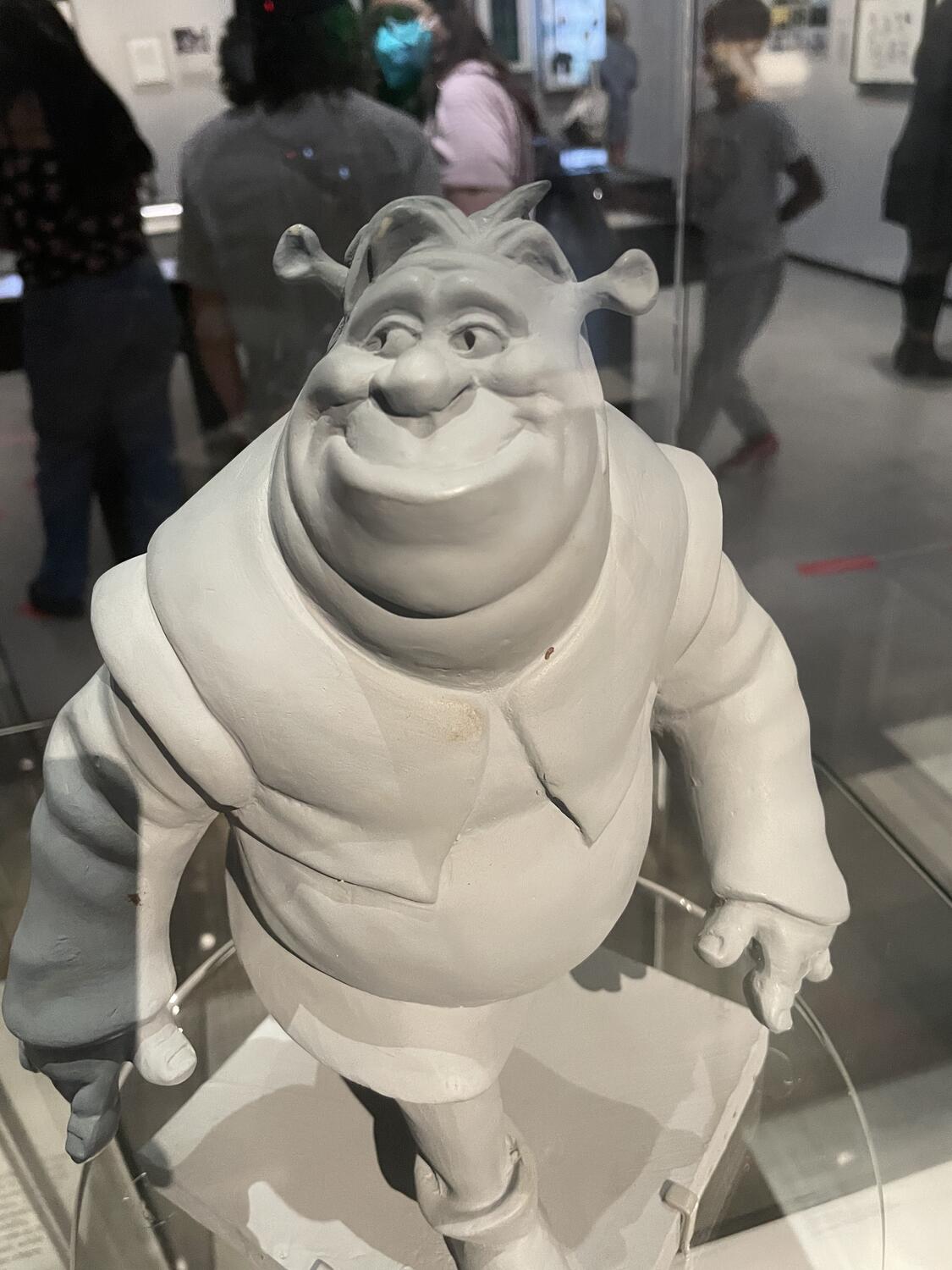 A clay maquette of Shrek. It looks mostly like the ogre we know, but his clothes are different and he has a funny shock of hair on the top of his head