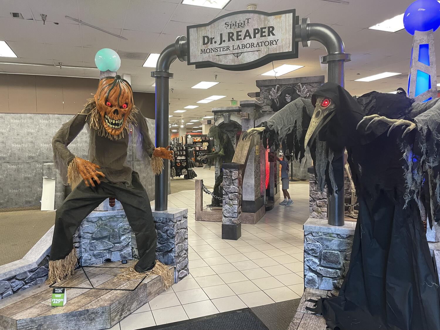 Various animatronics set up at the entrance to the store in an immersive display that is wholly overpowered by the flourescent lighting of a former Sears