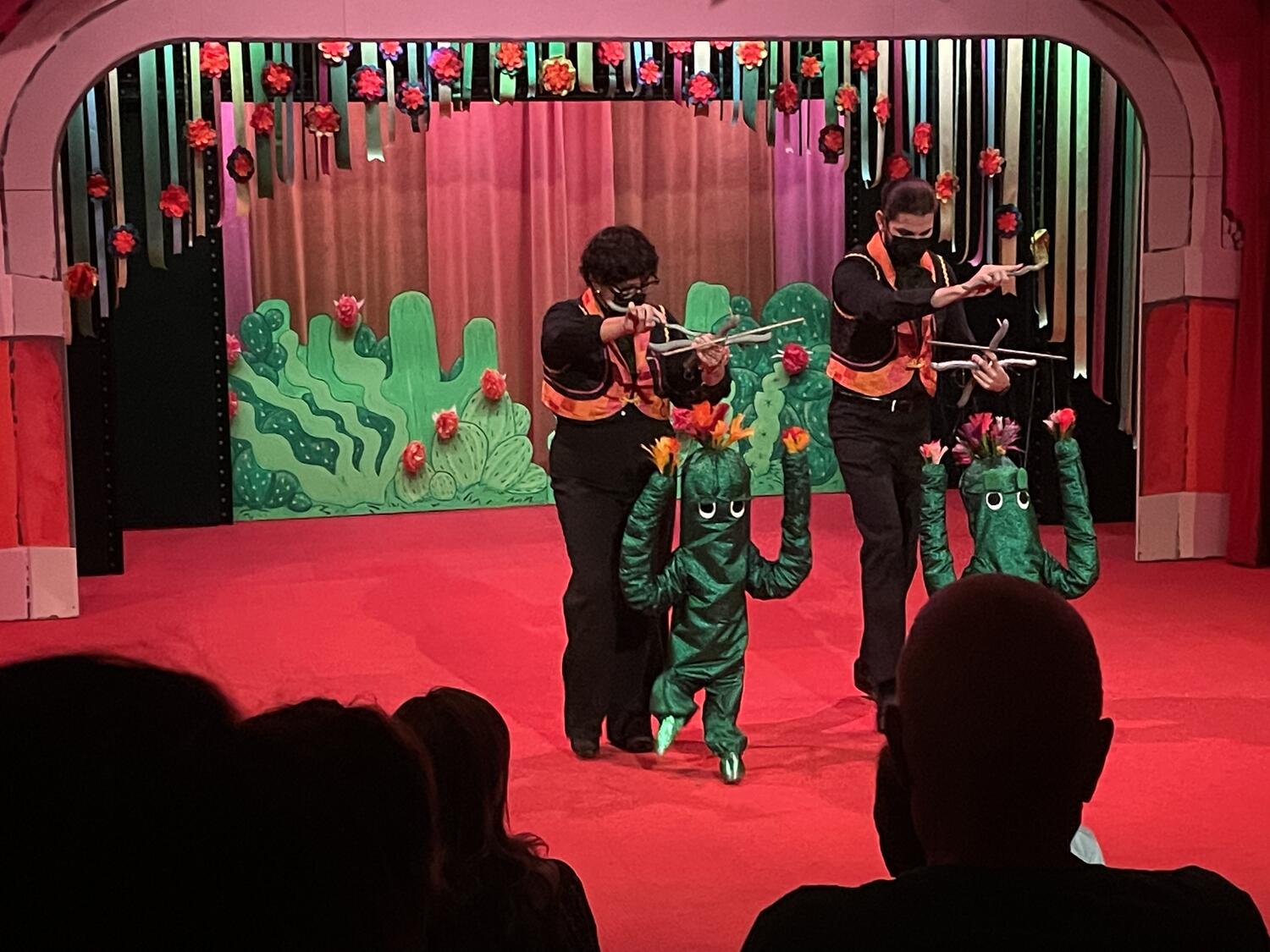 Two cactus puppets dancing in unison. The background is more cacti!