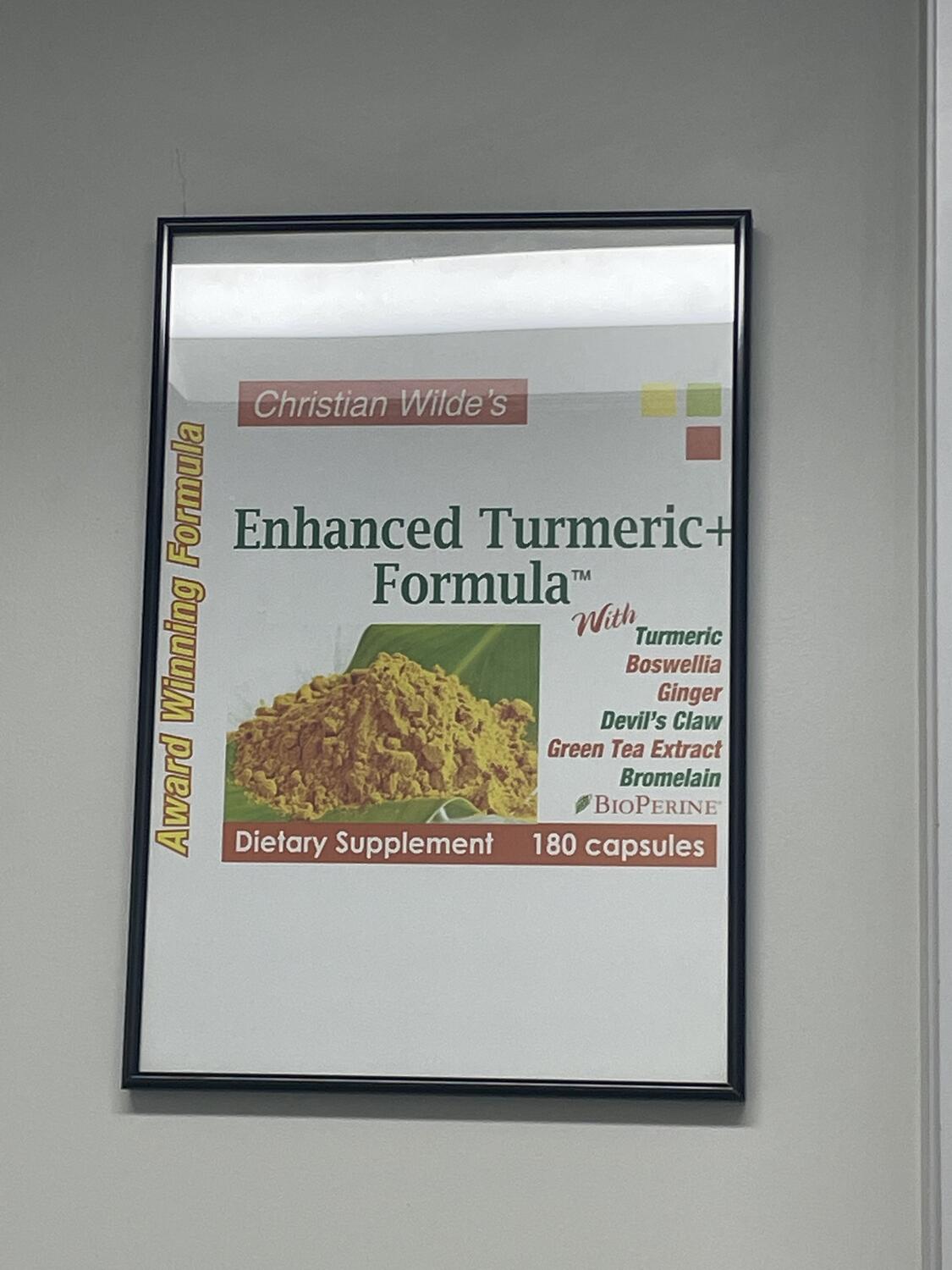 A janky printed ad for “Christian Wilde’s Enhanced Turmeric Formula™ Dietary Supplement.” It's framed, but clearly wasn't designed for the shape of frame it's in. Awkward all around.