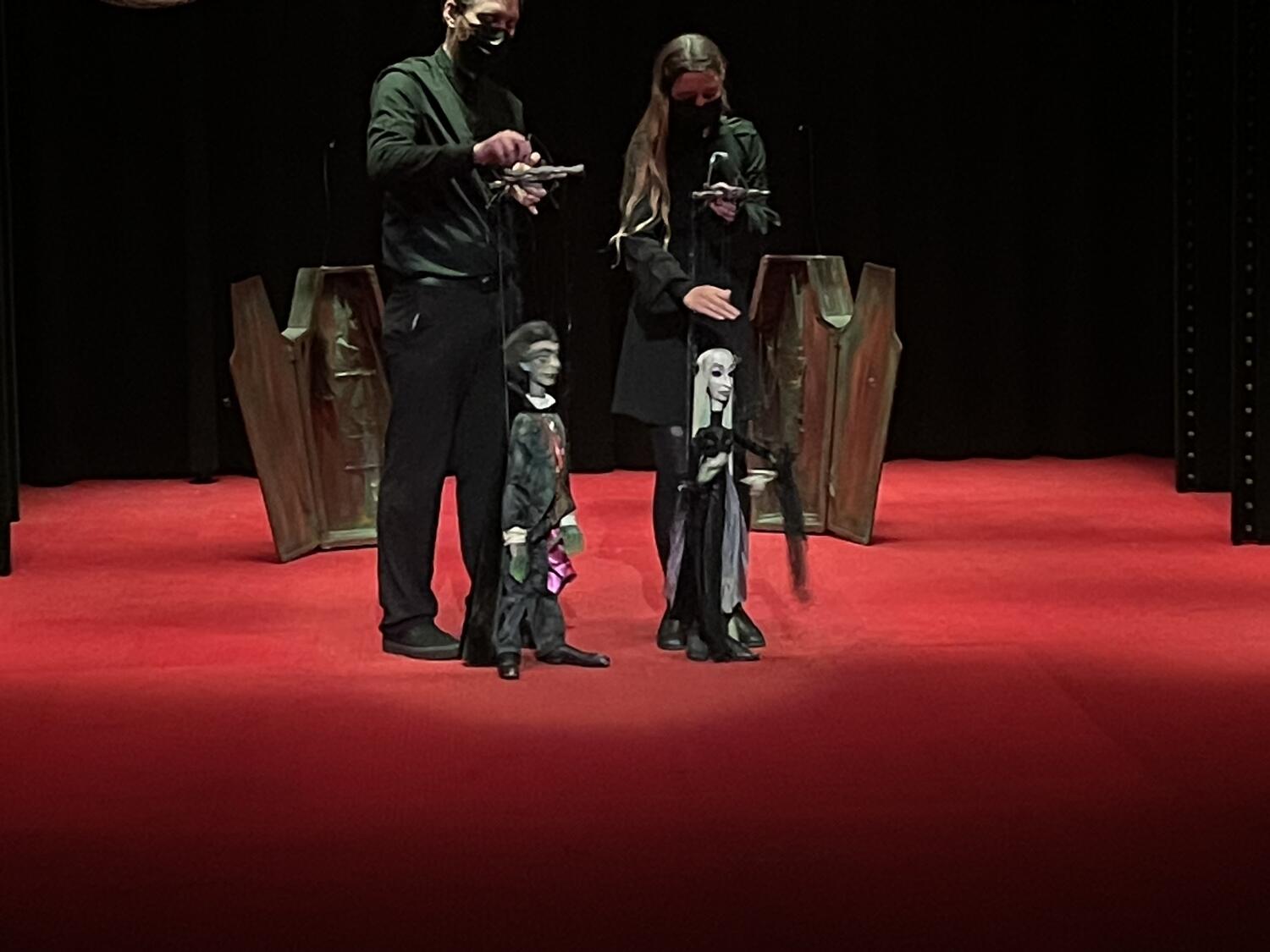 Two puppets: a vampire couple, recently having emerged from their open coffins