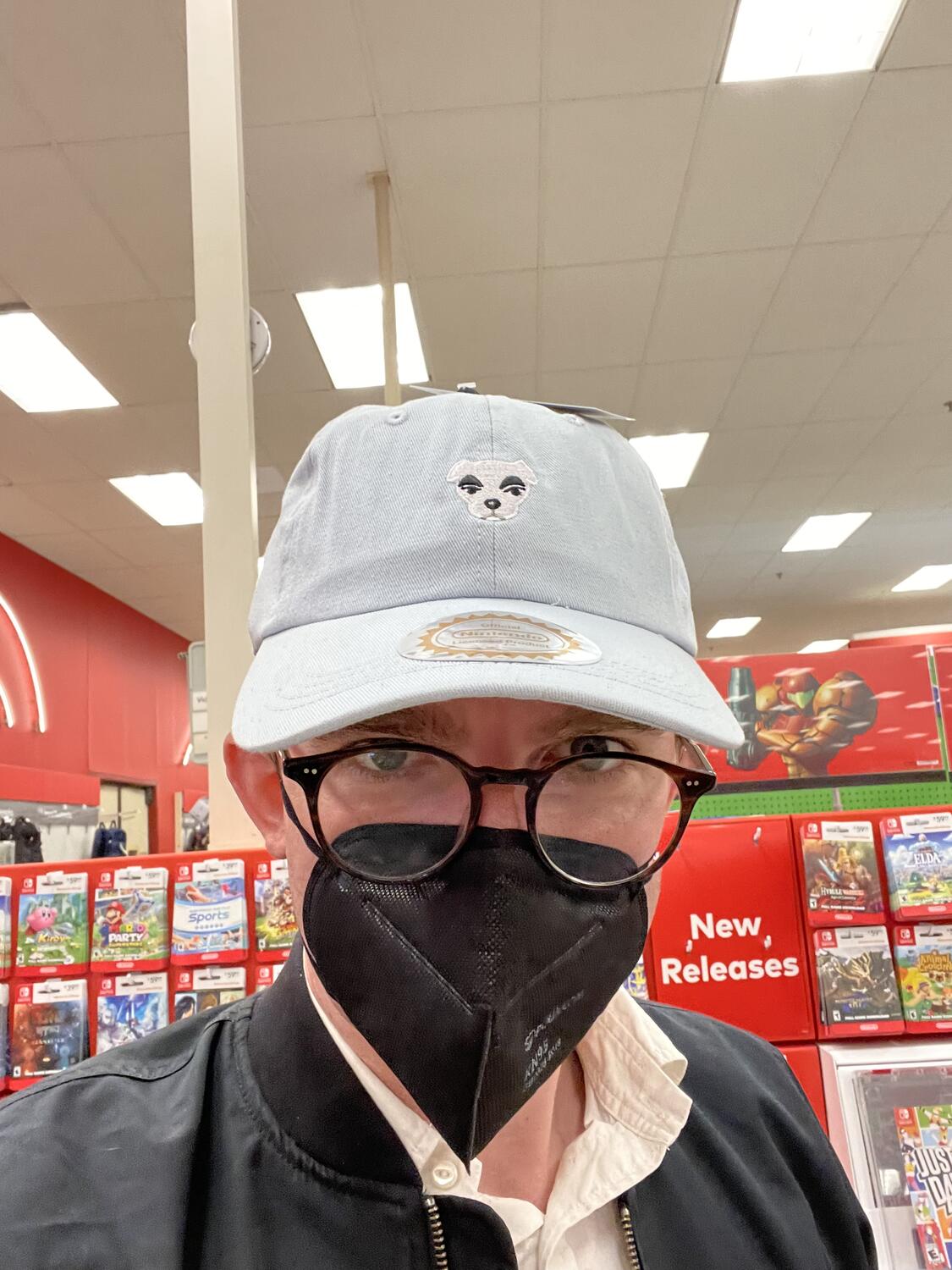 A selfie at Target in a blue baseball cap embroidered with the face of KK Slider