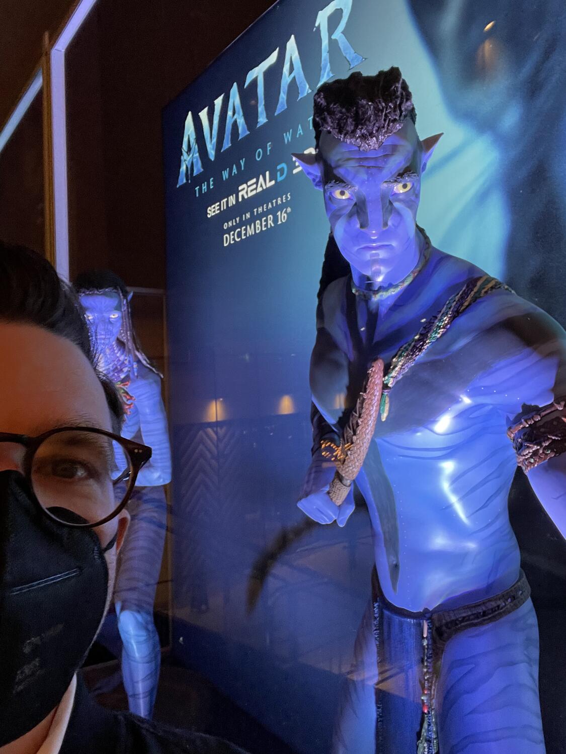 Life-size statues of two characters from Avatar in front of a large poster for the new movie