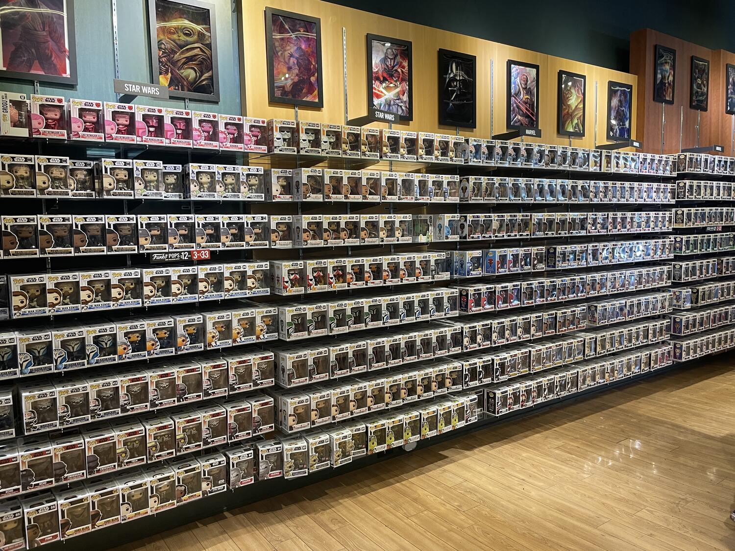 A wall in a narrow store in a mall that is just absolutely covered with Funko Pops